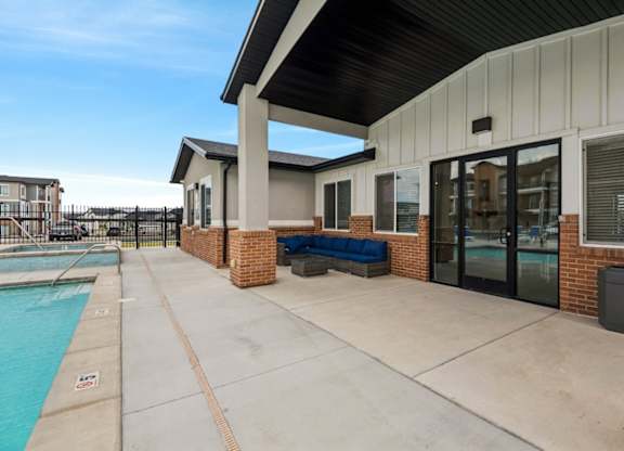 A poolside area with a bench and a building in the background.