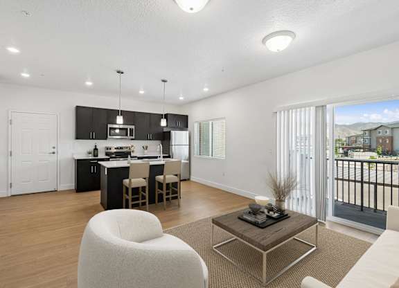 A modern kitchen with a dining area and a living room.