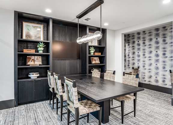 A modern dining room with a dark wood table and chairs.