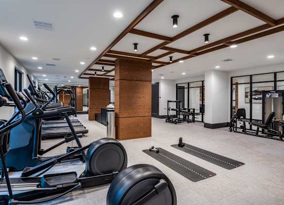 A gym with treadmills, weights, and exercise equipment.