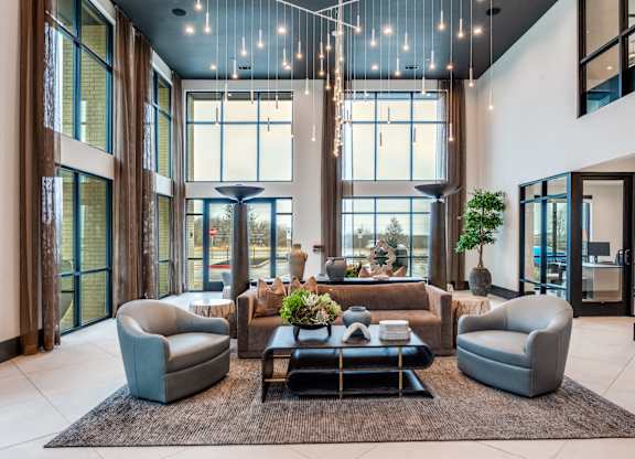 A modern living room with a large window and a rug on the floor.