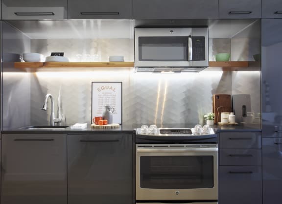 a small kitchen with gray cabinets and stainless steel appliances