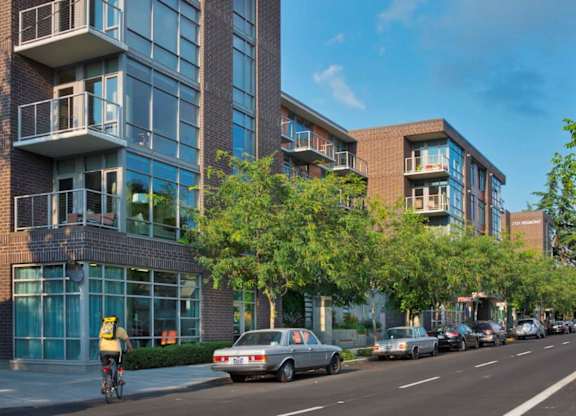Exterior view of tree-surrounded 2121 Belmont apartments building in the Buckman neighborhood in Portland, Oregon.