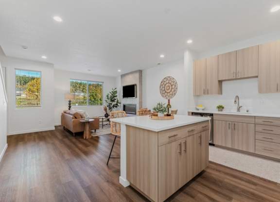 A modern kitchen with wooden floors and cabinets.