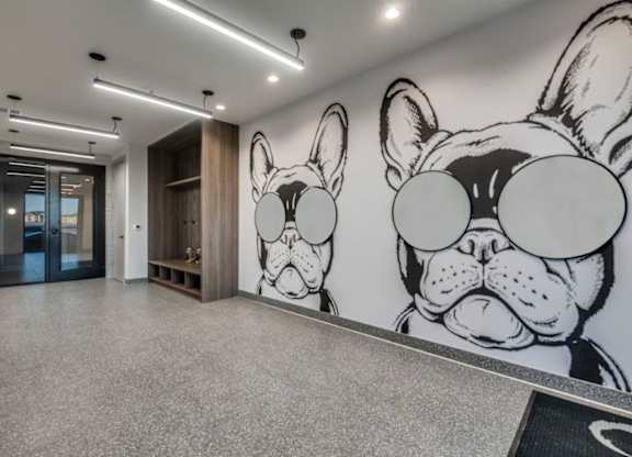 A hallway with a large mural of a dog's face on the wall.