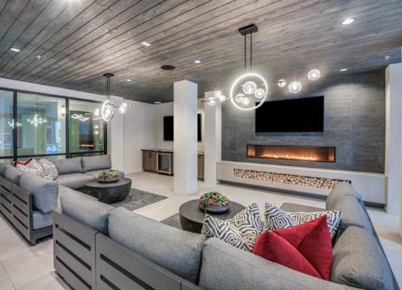 A modern living room with a grey sofa and a fireplace.