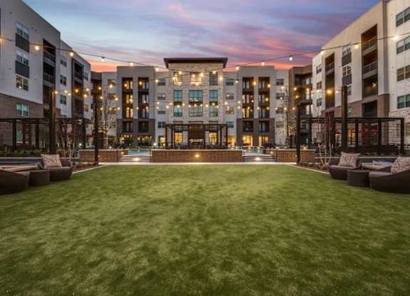 A large grassy area in front of apartment buildings.