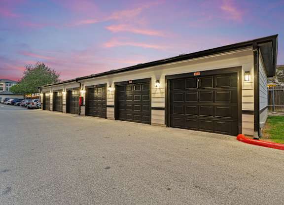 A long building with black garage doors.