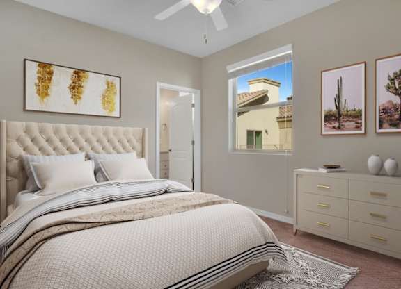 A bedroom with a large bed, a ceiling fan, and a window showing a house outside.