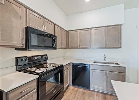 A kitchen with a black stove and microwave.