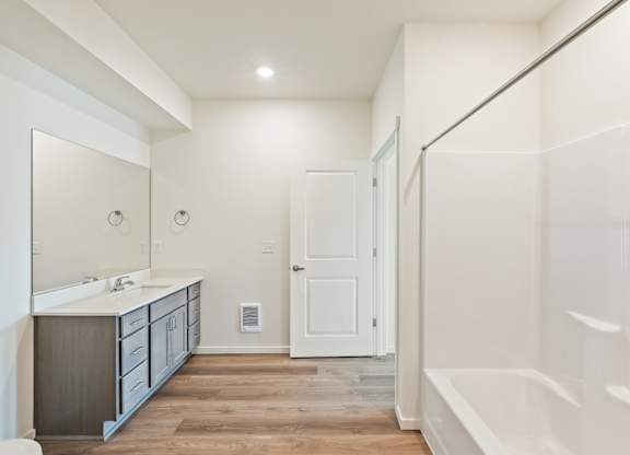 A bathroom with a white door and a white sink.