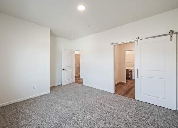 A room with white walls and a grey carpet.