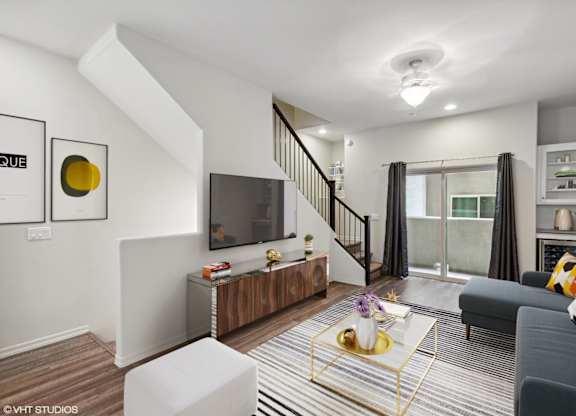A living room with a grey couch and a white coffee table.