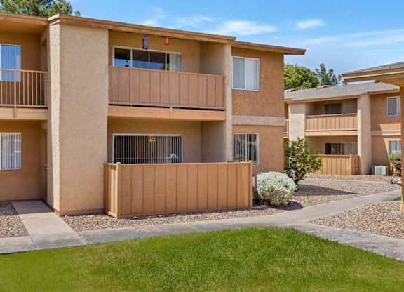 A sunny day at a residential complex with apartments and green lawns.
