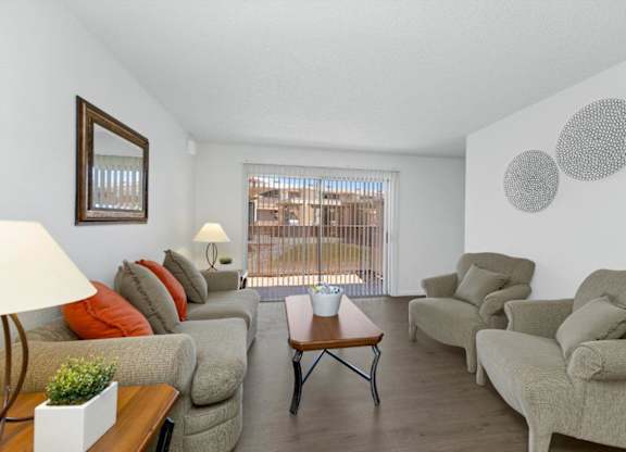 A living room with a couch, chairs, and a table.