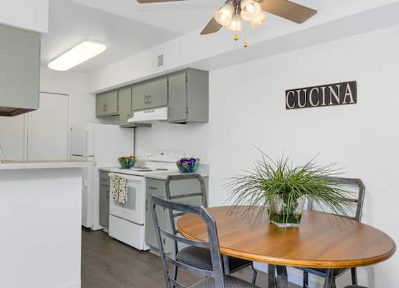 A kitchen with a table and chairs and a sign that says Cucina.