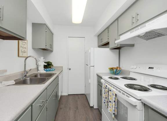 A kitchen with white appliances and a white refrigerator.