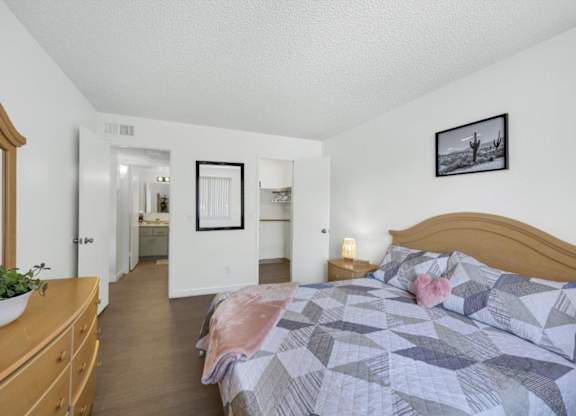 A bedroom with a bed, dresser, and mirror.