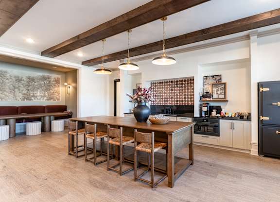 A kitchen with a wooden table and chairs.