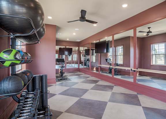 A gym with a checkered floor and exercise equipment.