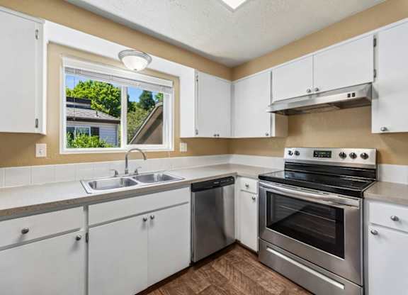 A kitchen with white cabinets and stainless steel appliances.