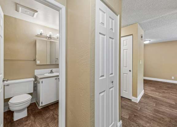A bathroom with a toilet, sink, and mirror.