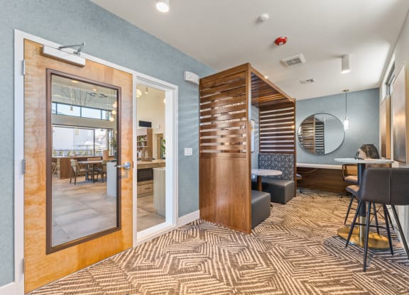 a lobby with a bar and a dining room with a table and chairs