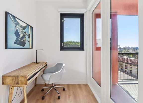 A room with a desk and chair with a window.
