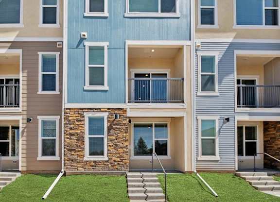 A modern apartment building with a blue, beige, and brown facade.