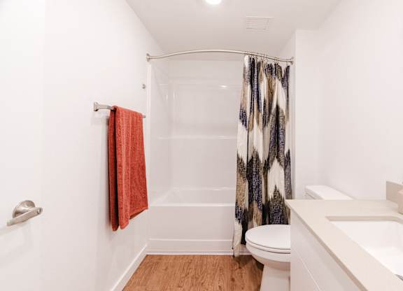 A white bathroom with a toilet, sink, and shower.