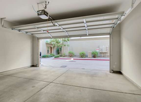 A large, empty garage with a view of a parking lot and a building outside.