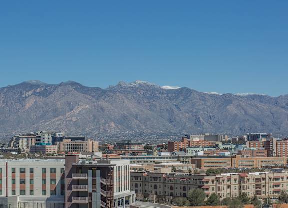 A cityscape with buildings and mountains in the background at Herbert Residential, Tucson, AZ