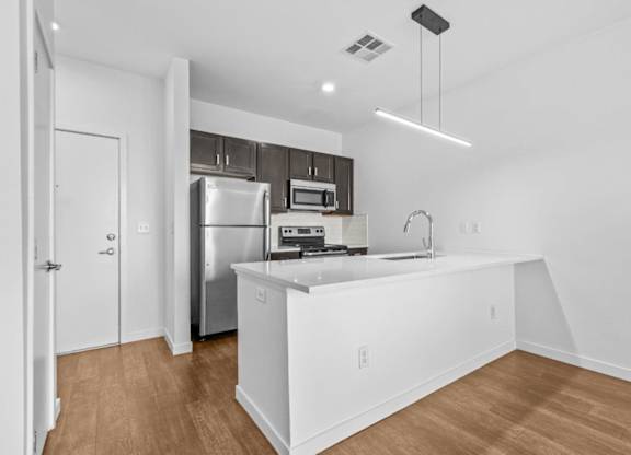 A modern kitchen with white cabinets and stainless steel appliances.