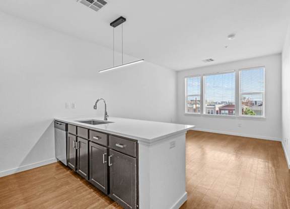 A kitchen with a white countertop and wooden flooring.