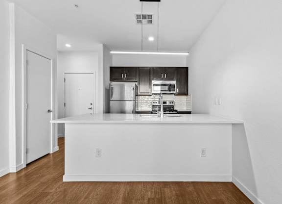 A modern kitchen with white cabinets and stainless steel appliances.