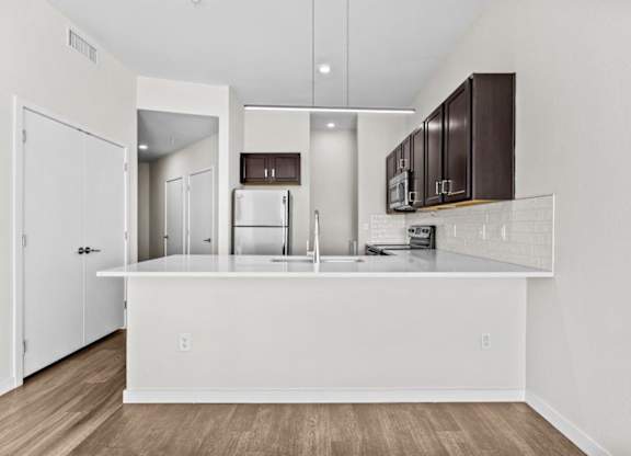 A kitchen with white cabinets and a white island.