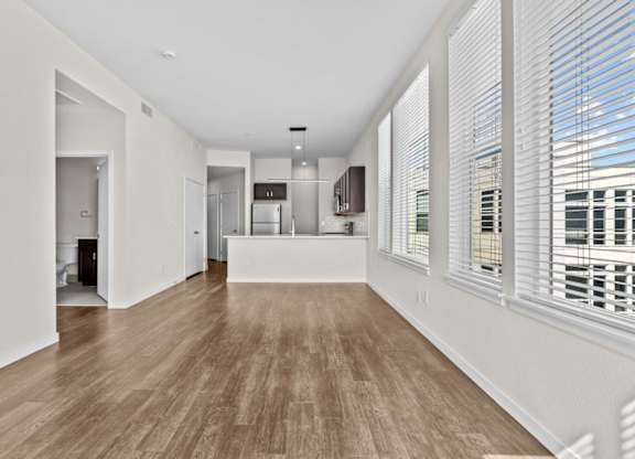 A spacious room with wooden floors and white walls.