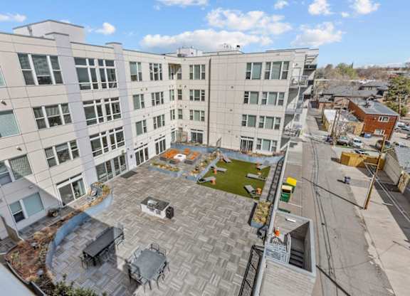 A large white building with a patio and a fire pit.
