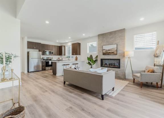 A modern kitchen with a refrigerator, microwave, and oven.