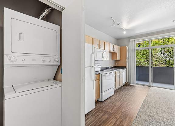 A white oven and refrigerator in a kitchen with wooden floors.
