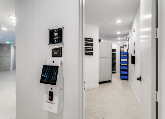 the hallway of a building with a white wall and electronics on it