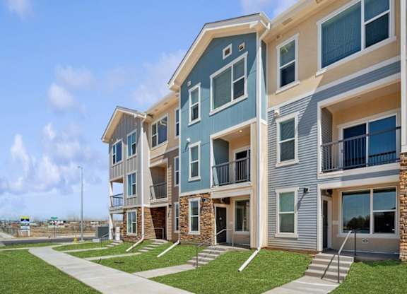 A modern apartment building with balconies and multiple windows.