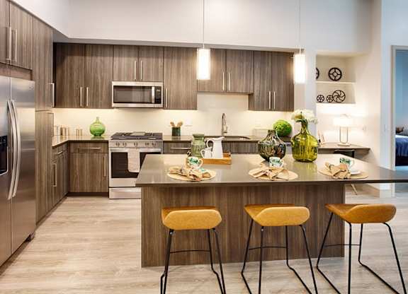 A modern kitchen with a large island and stools.