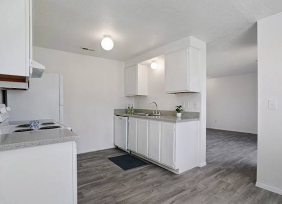 A kitchen with white cabinets and a granite countertop.