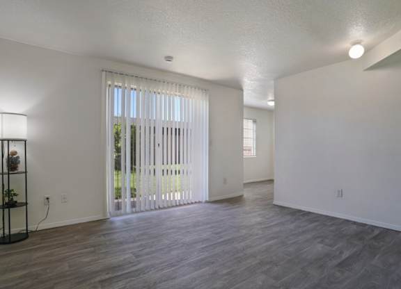 A room with a wooden floor and a sliding glass door.