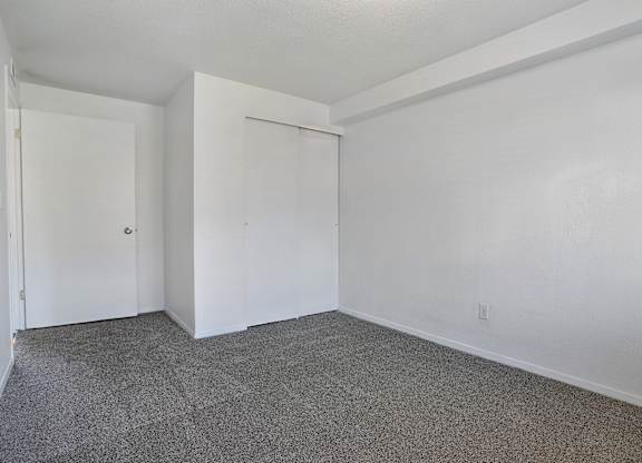 A room with white walls and carpeted floor.