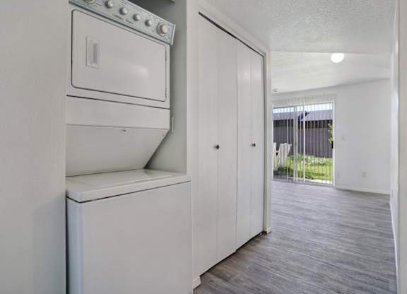 A white fridge in a room with a door open.