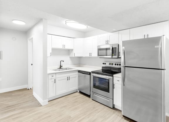 Proximity Apartment Homes Kitchen with stainless steel appliances and white cabinets
