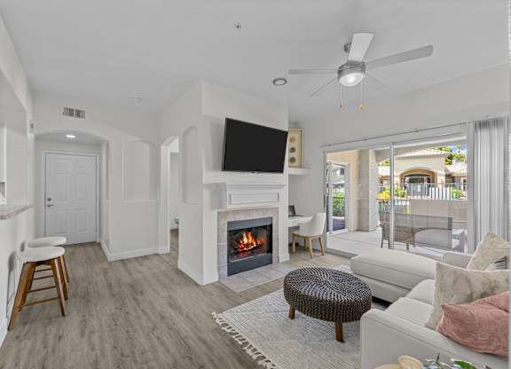 A living room with a fireplace and a flat screen TV.