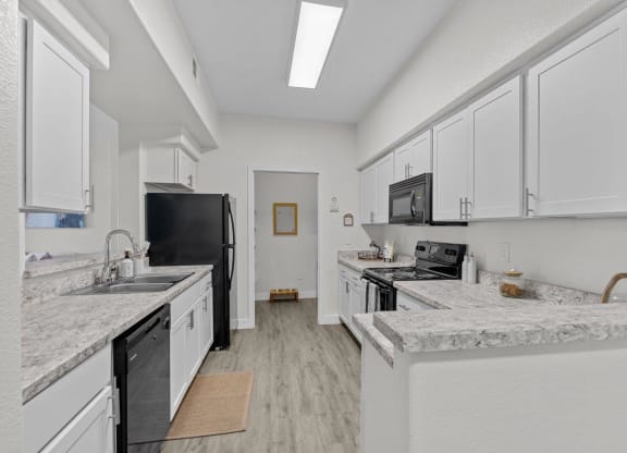 a kitchen with marble counter tops and white cabinets
